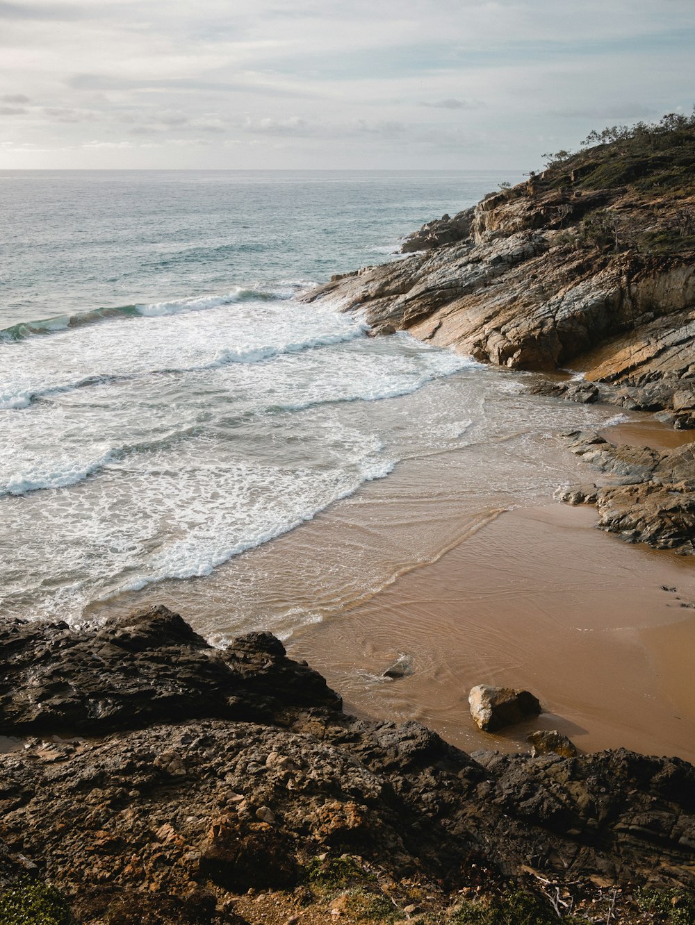 formação rochosa marrom na costa do mar durante o dia