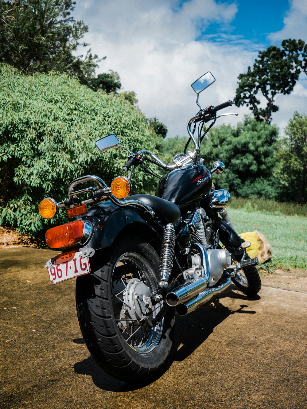 Moto noire et orange sur un chemin de terre marron