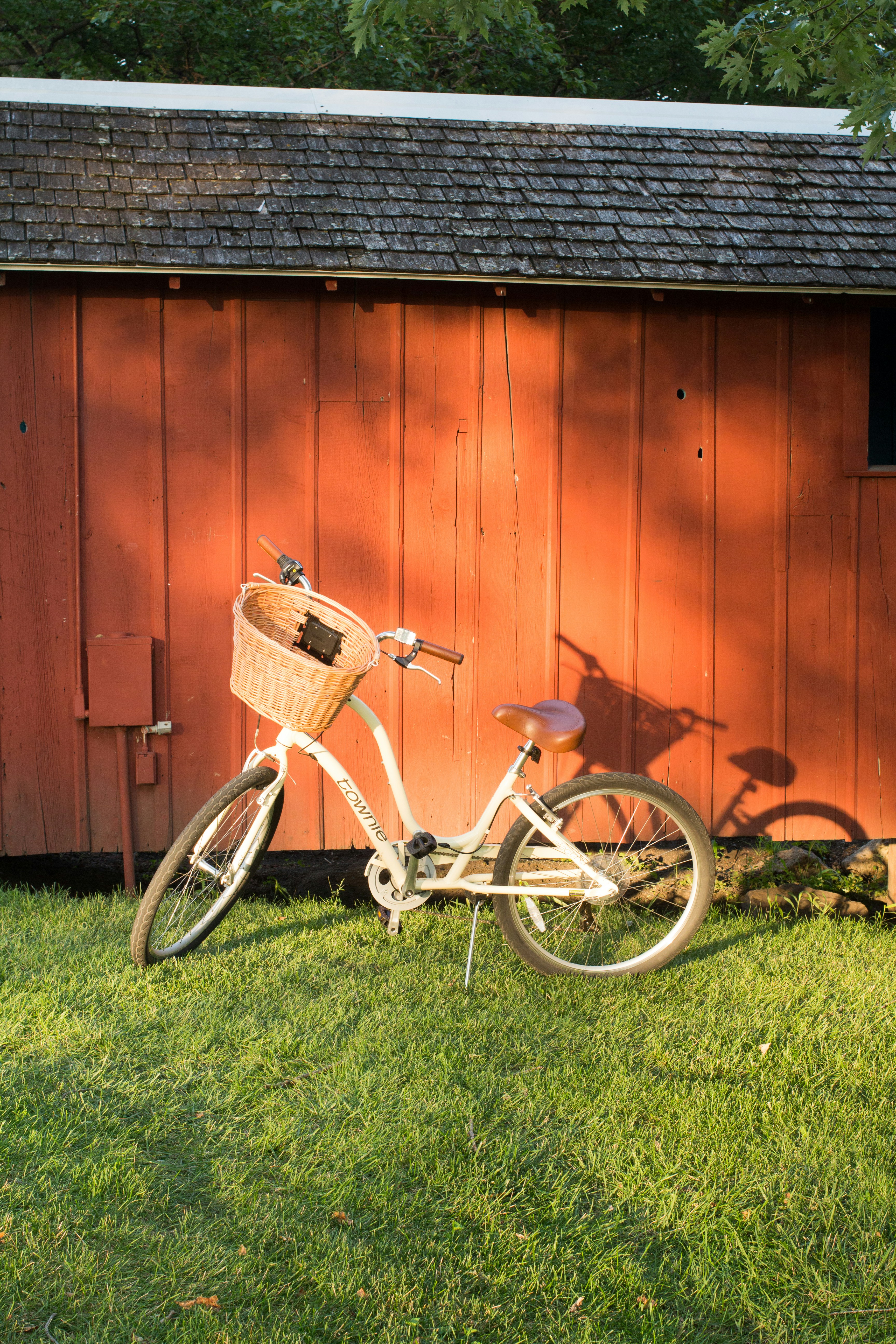 white and black city bike parked beside brown wooden wall