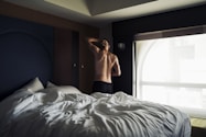 person in black shorts lying on bed
