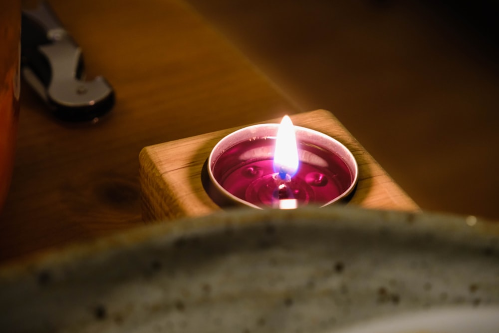 lighted candle on brown wooden holder