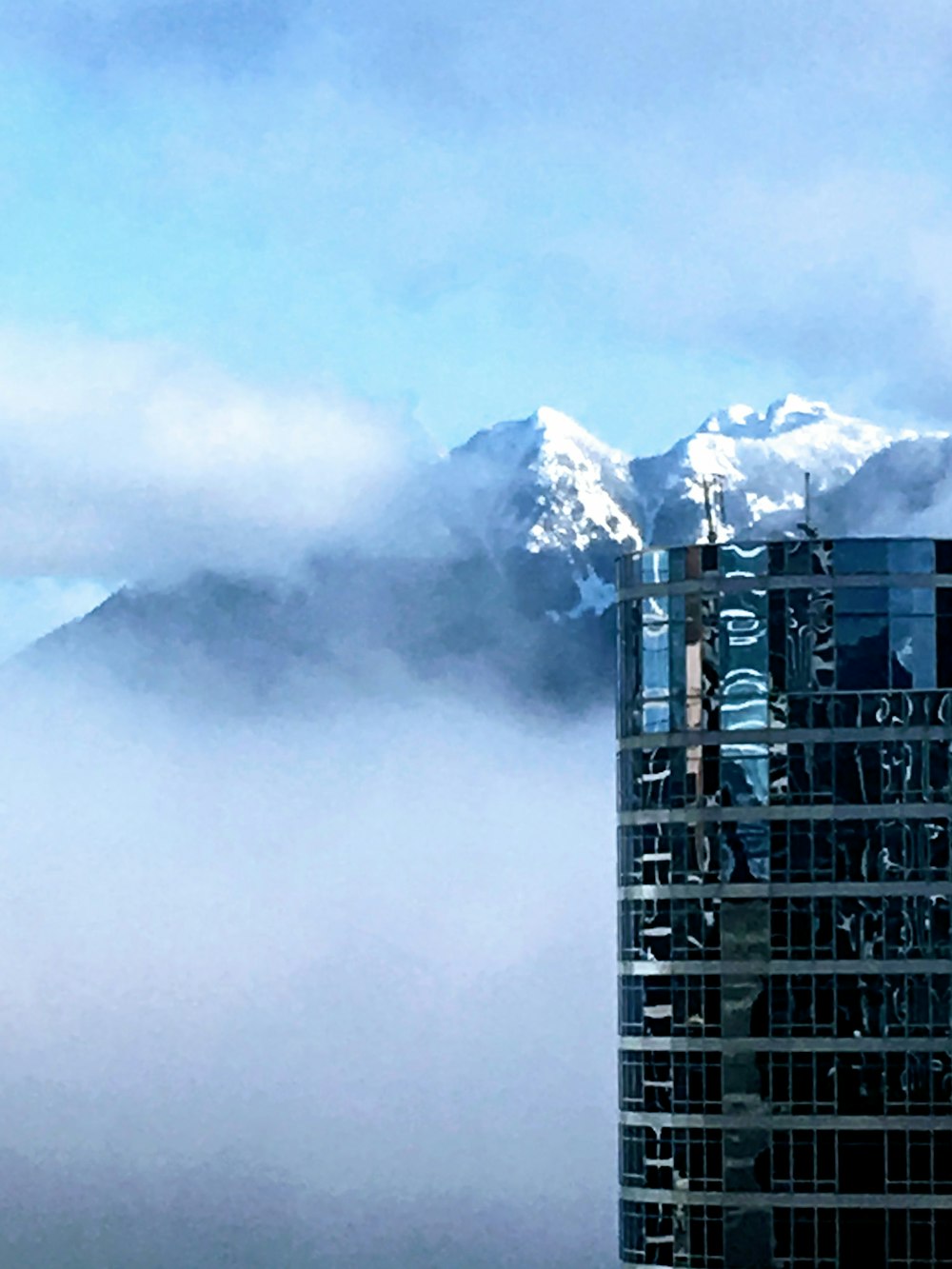 black building near snow covered mountain during daytime