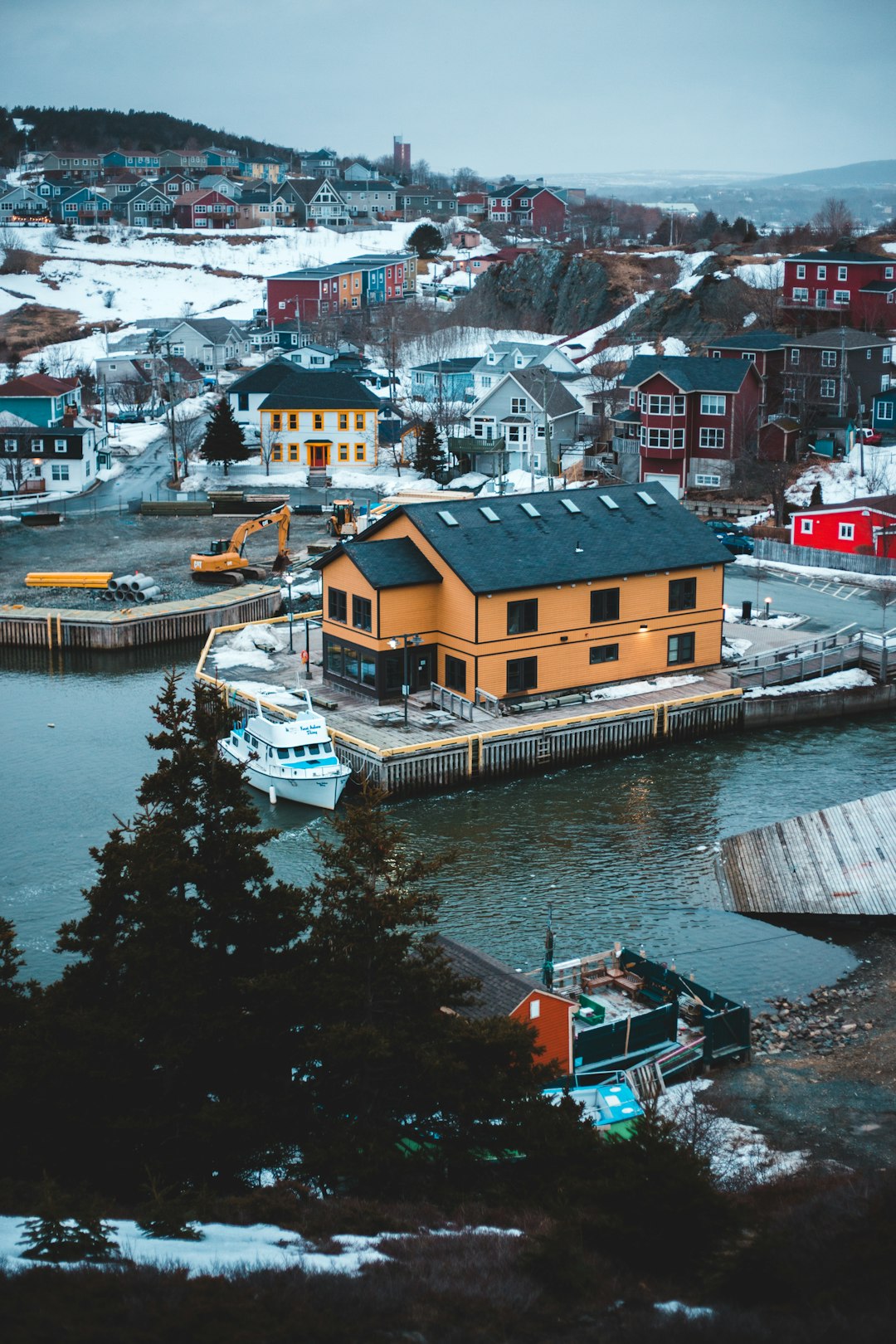 white and brown boat on water near houses during daytime