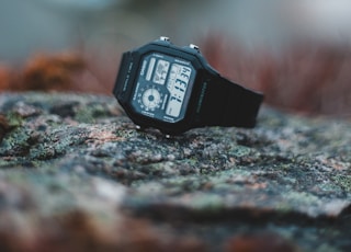 black digital watch on gray rock