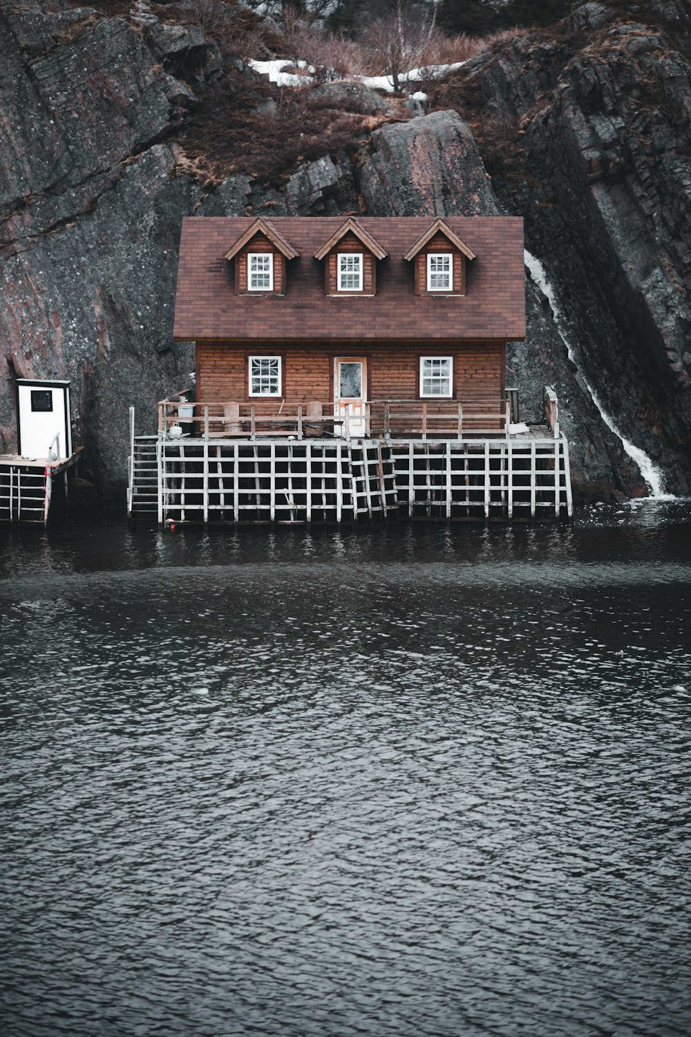 brown and white house beside body of water