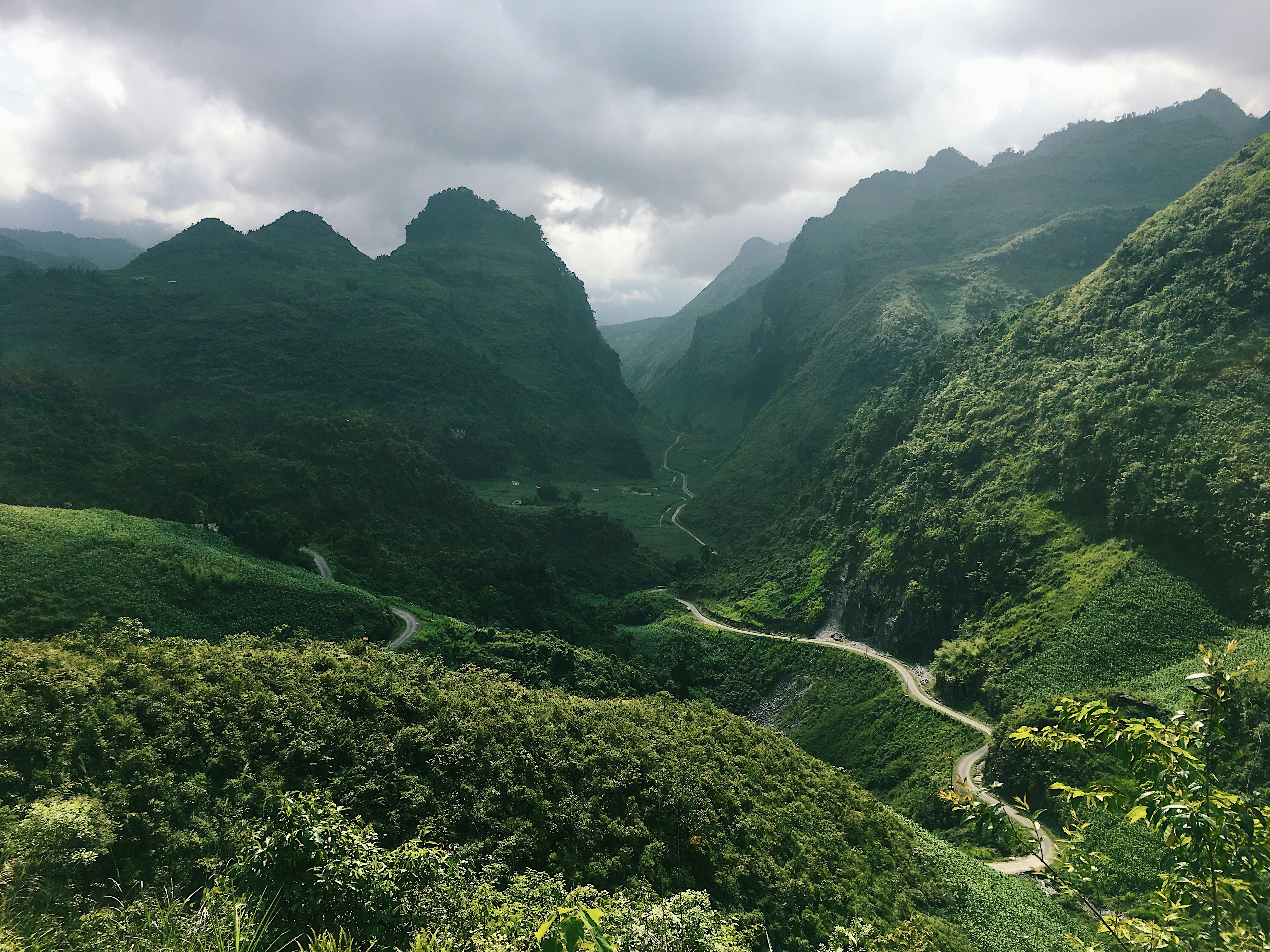 green mountains under white clouds during daytime, This was taken while on a four day motorbike trip round the North of Vietnam, right along the Chinese/ Vietnam border. Riding through the mountains offered the most spectacular views and an unreal experience.
