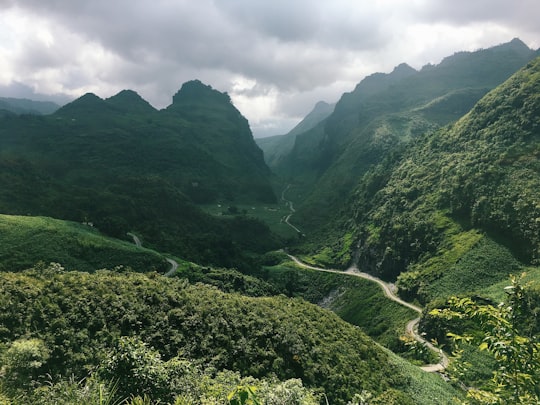 green mountains under white clouds during daytime in Ha Giang Vietnam