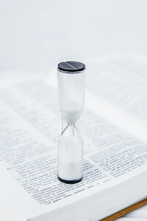clear glass hour glass on white paper reflecting perfect peace