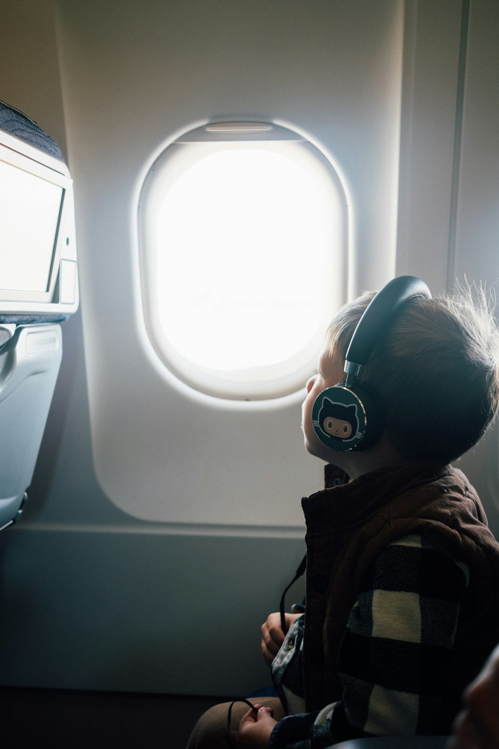 girl in red and brown sweater wearing white and blue headphones