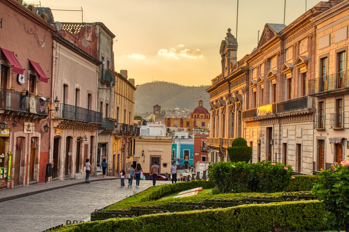 Jardín de la Unión Guanajuato — the triangular main plaza with the ornate neoclassical facade of Teatro Juárez rising behind the laurel trees and open-air seating