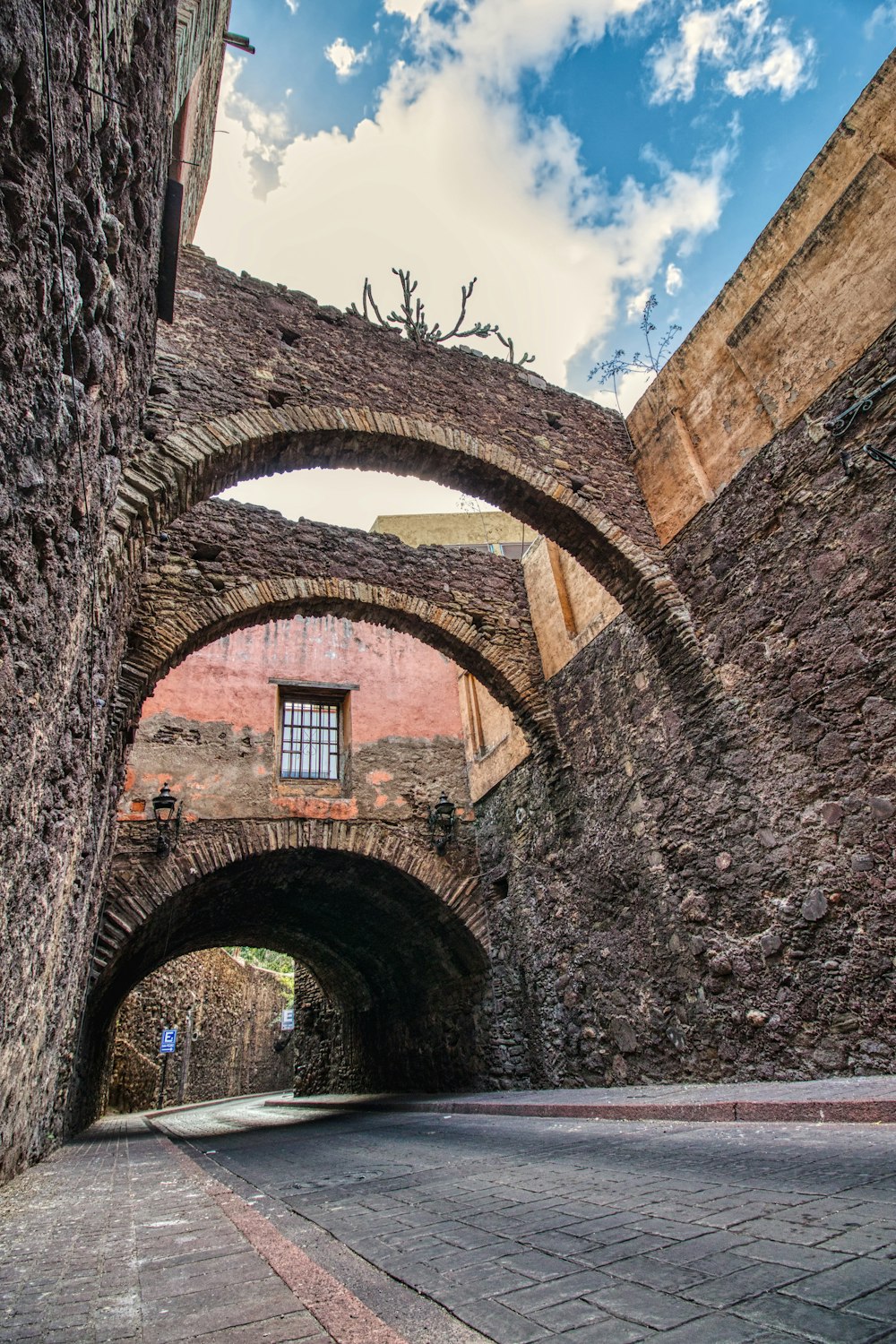 brown brick arch under blue sky during daytime