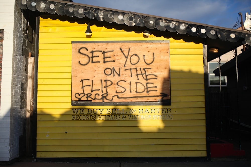 yellow and black wooden wall with black and white graffiti