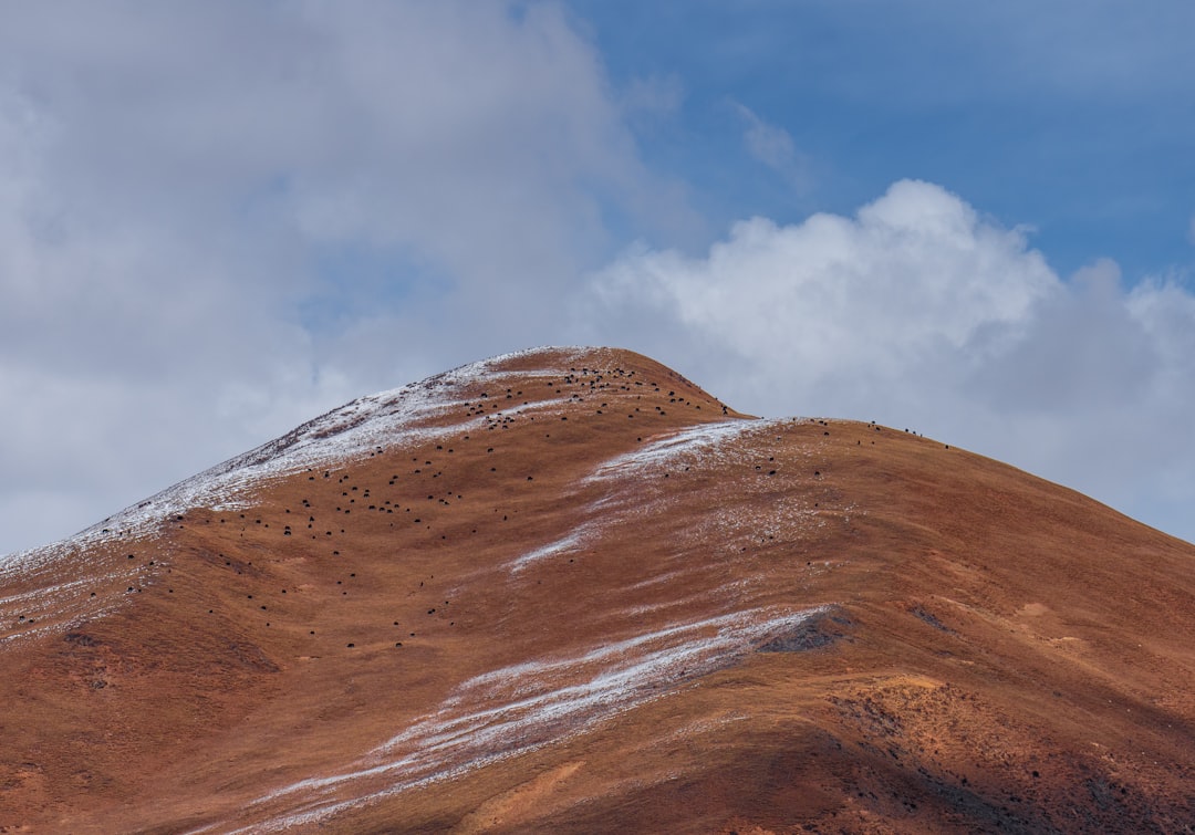 brown mountain under white clouds during daytime