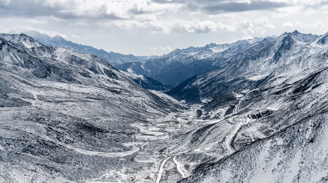 snow covered mountains under cloudy sky during daytime