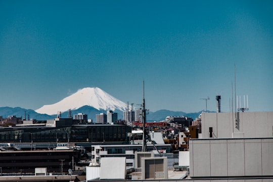 white and black concrete building near white and black mountain under blue sky during daytime in Itabashi Japan