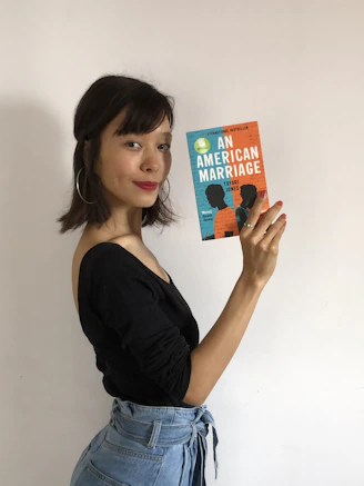 A close-up of an author holding their latest novel.