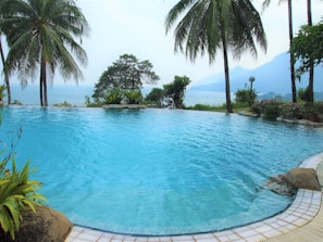 An infinity pool overlooking a tranquil mountain landscape at a luxury resort.