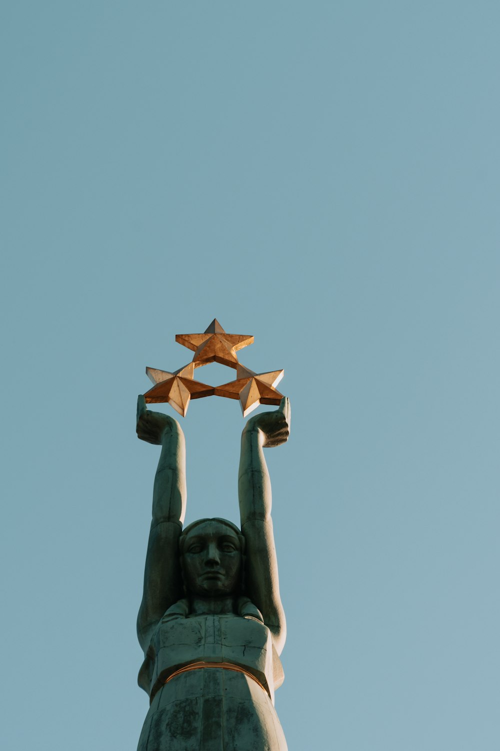 Estatua de hormigón marrón bajo el cielo azul durante el día