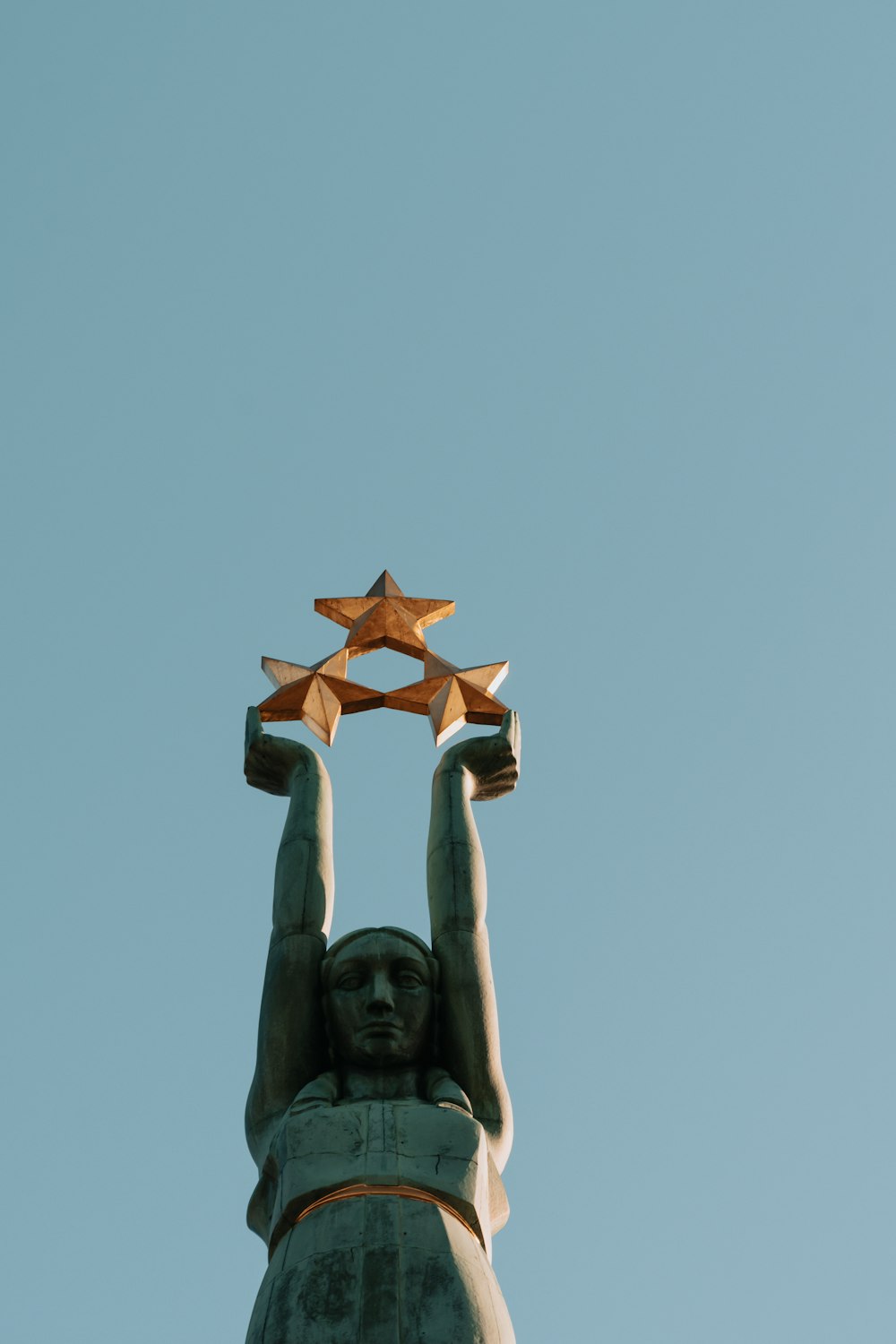 estátua de concreto marrom sob o céu azul durante o dia