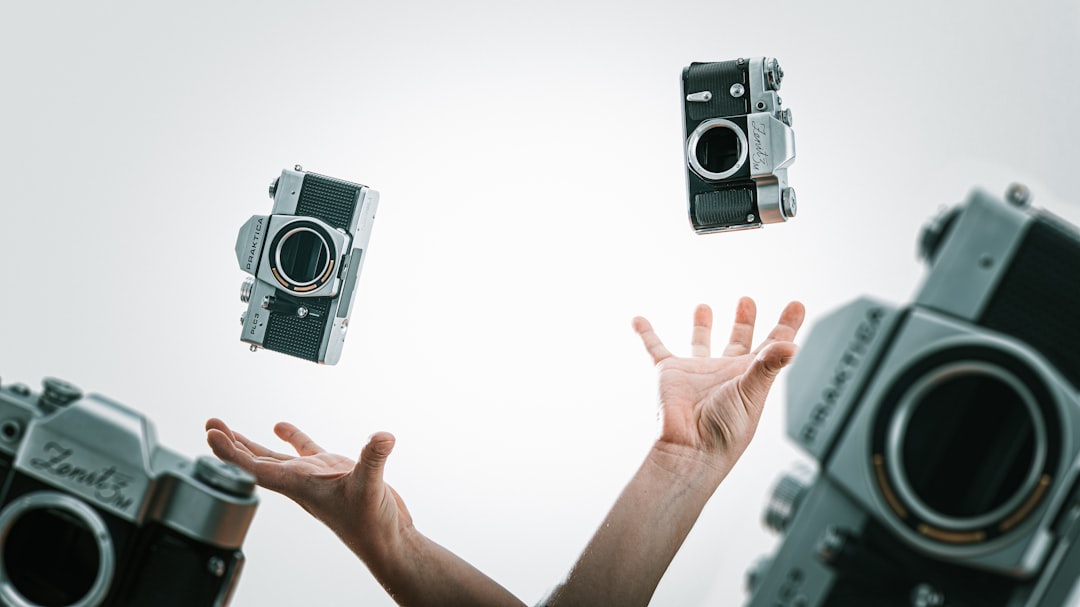 person holding black and silver camera