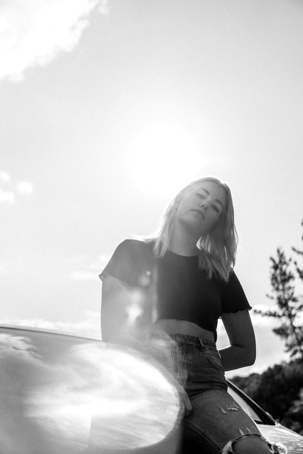 grayscale photo of woman in black crop top and blue denim jeans