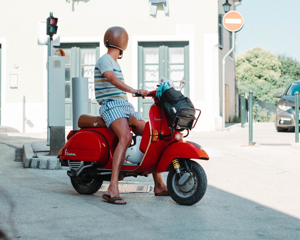 man in white t-shirt and black shorts riding red motor scooter photo – Free  Rovinj Image on Unsplash