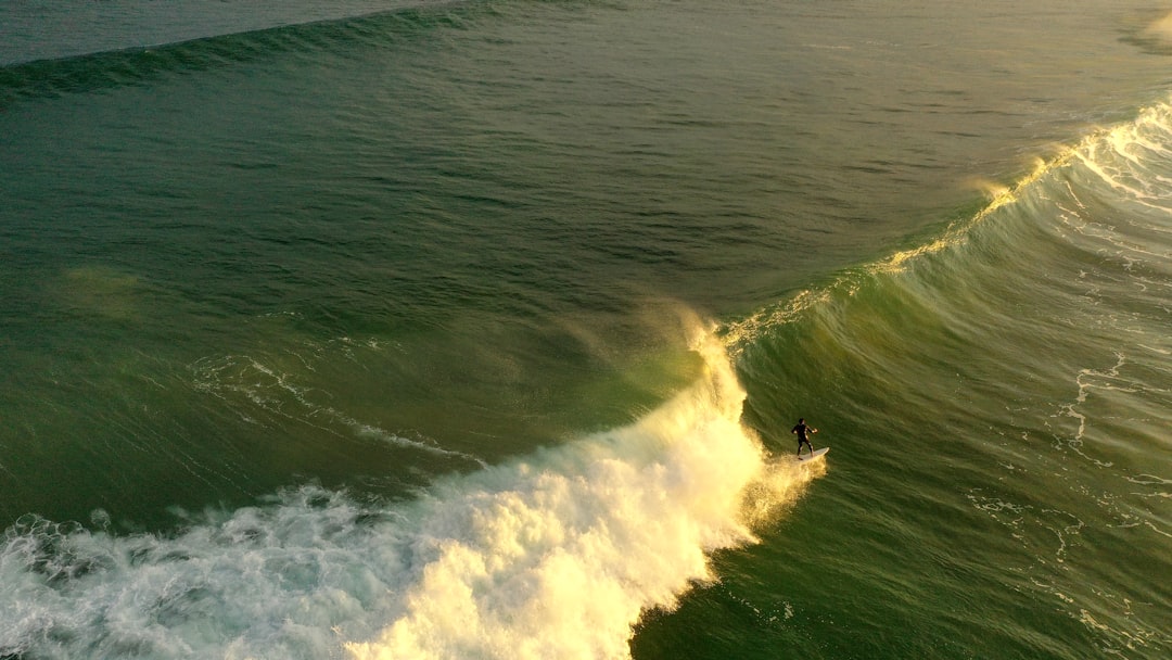 person surfing on sea waves during daytime