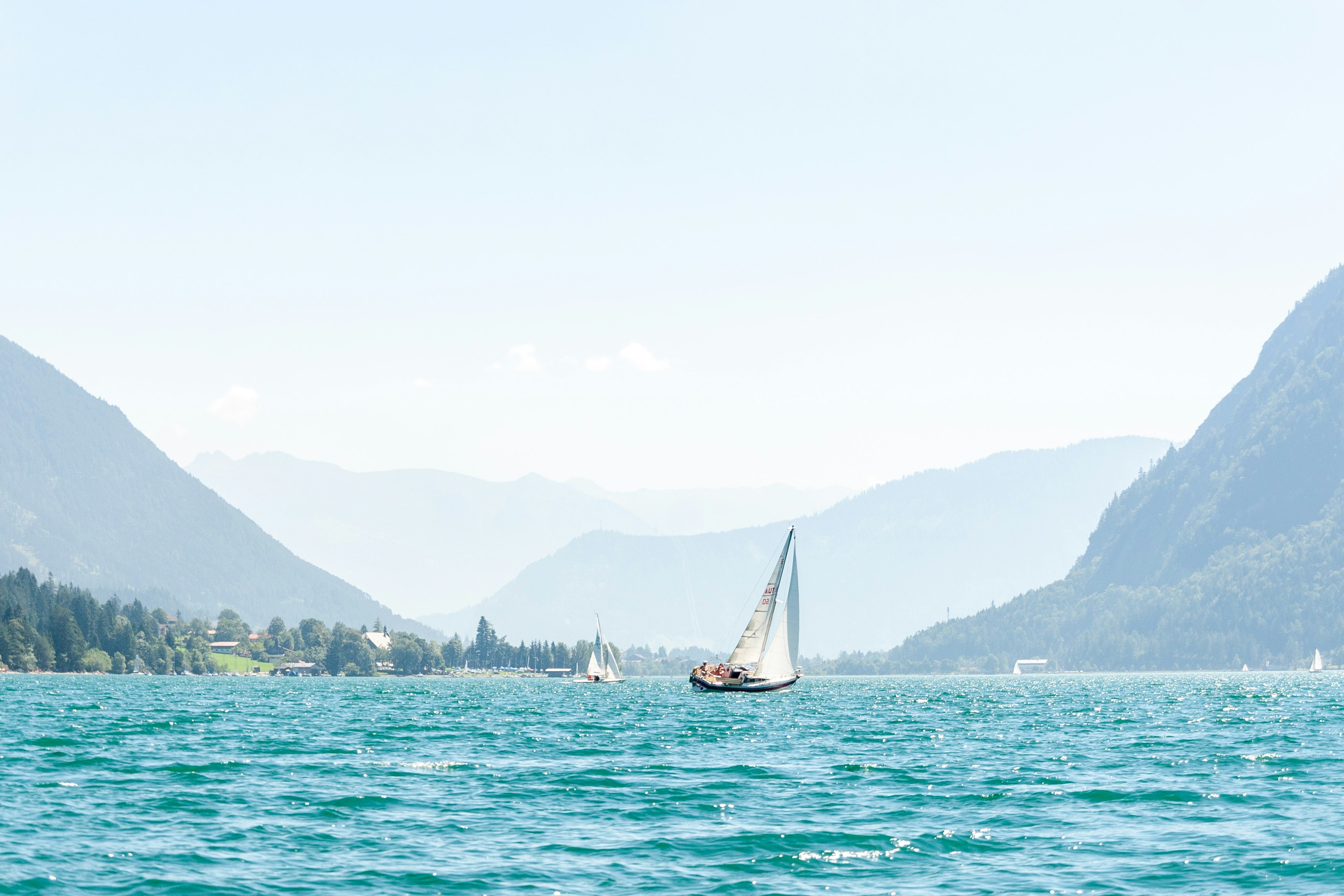 white sail boat on sea during daytime