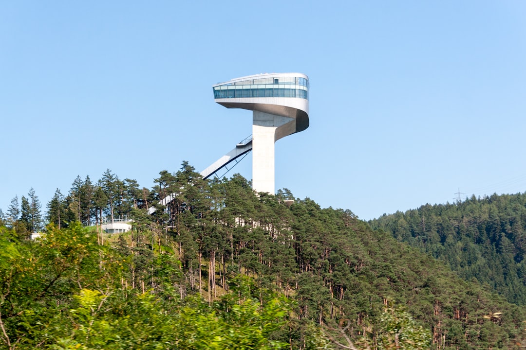 white and gray round building on top of green mountain