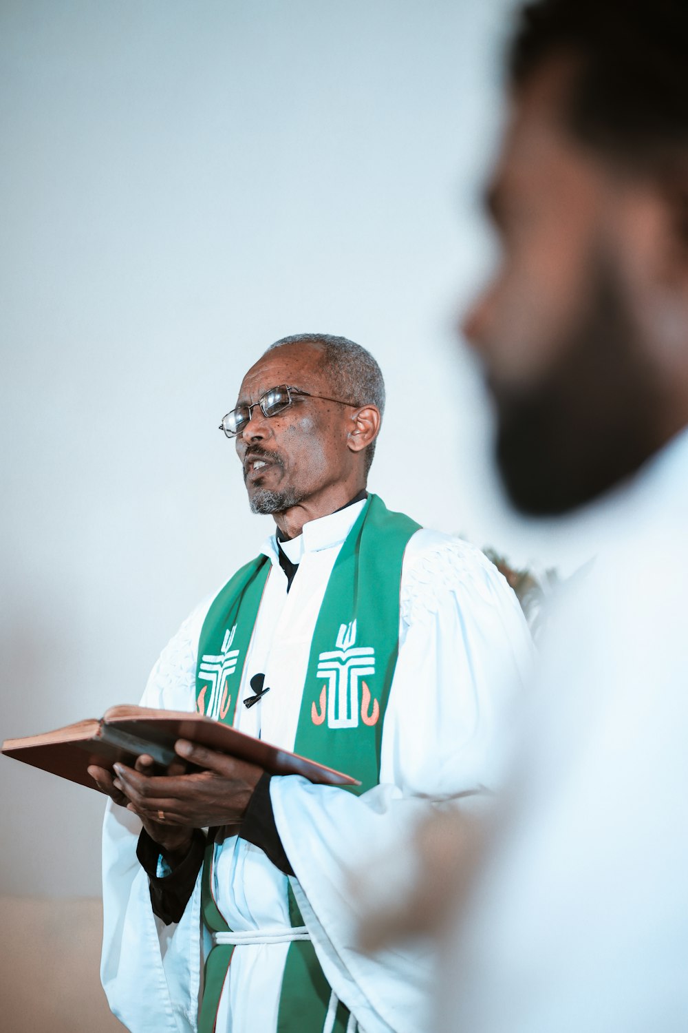 hombre con camisa blanca y verde sosteniendo un teléfono inteligente negro