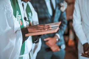Close-up of a leader holding a bible with a white and gold altar in the background