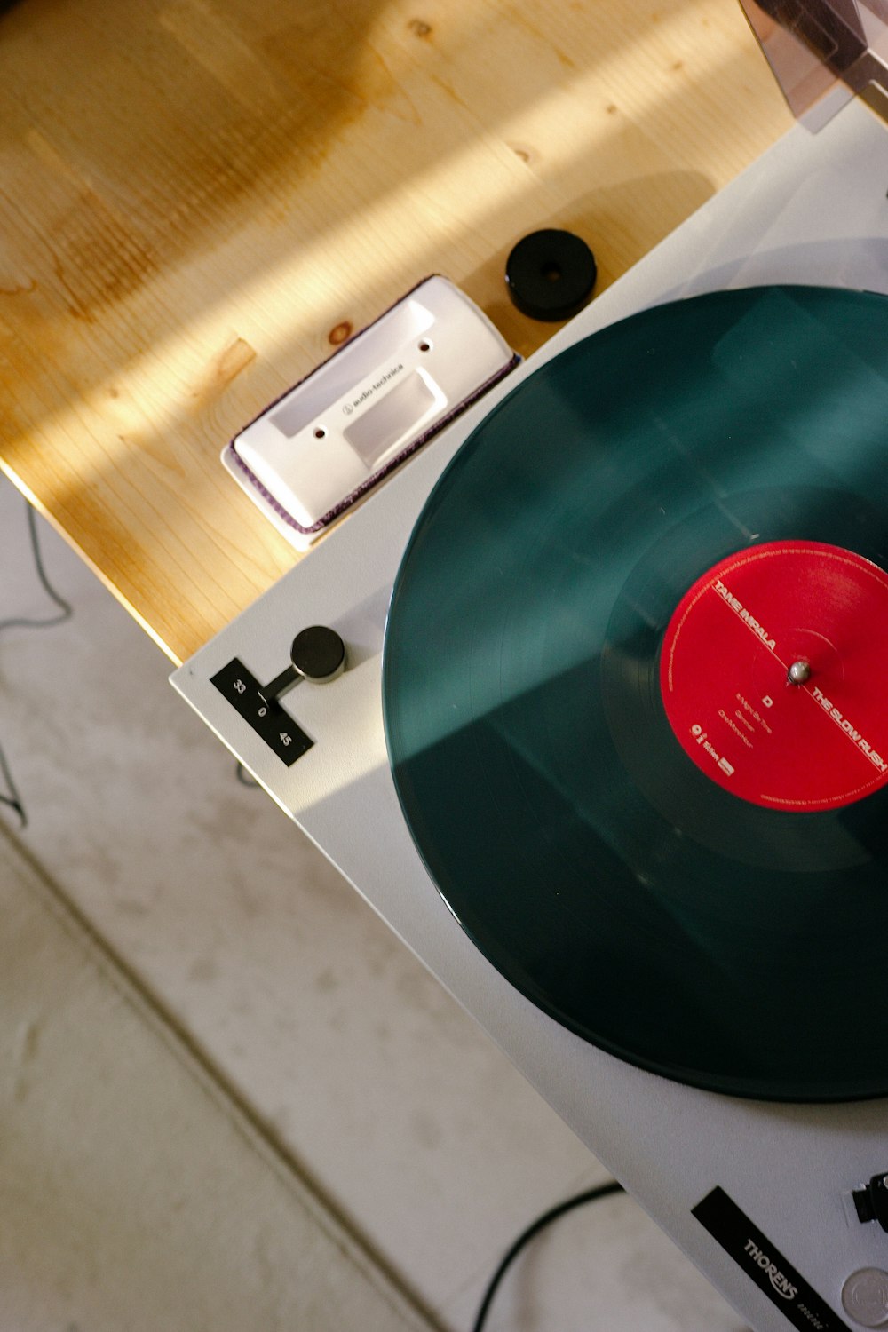 Disco de vinilo verde en toma de corriente blanca