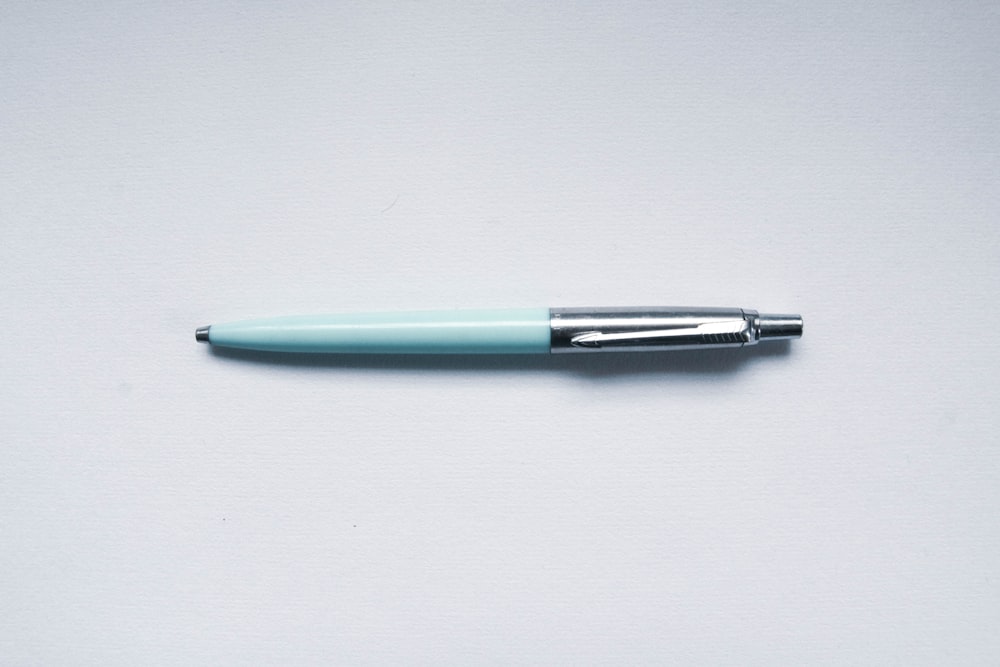 green and silver click pen