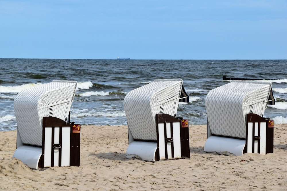 white and brown wooden chairs on beach during daytime