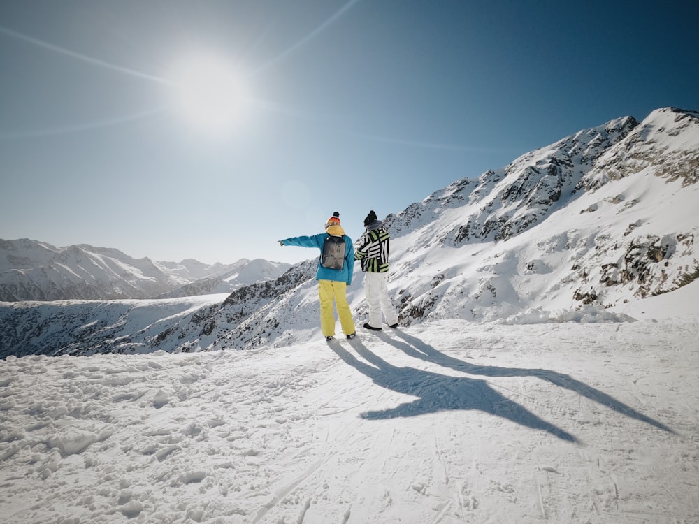 woman in blue jacket and yellow pants standing on snow covered ground during daytime