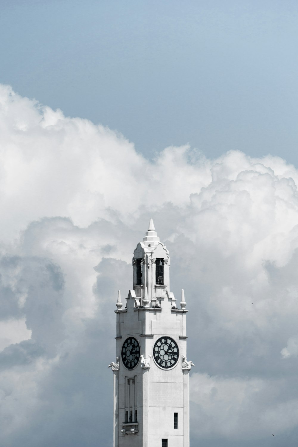 white and black concrete building under white clouds and blue sky during daytime