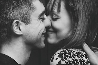 A close-up of a couple exchanging heartfelt smiles, capturing an intimate emotional moment.