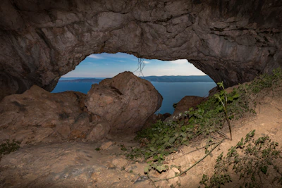 The famous Hercules Cave opening shaped like Africa, framing a stunning view of the sea beyond.