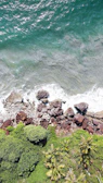 Panoramic view of the Santa Marta coastline with turquoise ocean waves and lush greenery.