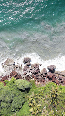Panoramic view of the Santa Marta coastline with turquoise ocean waves and lush greenery.