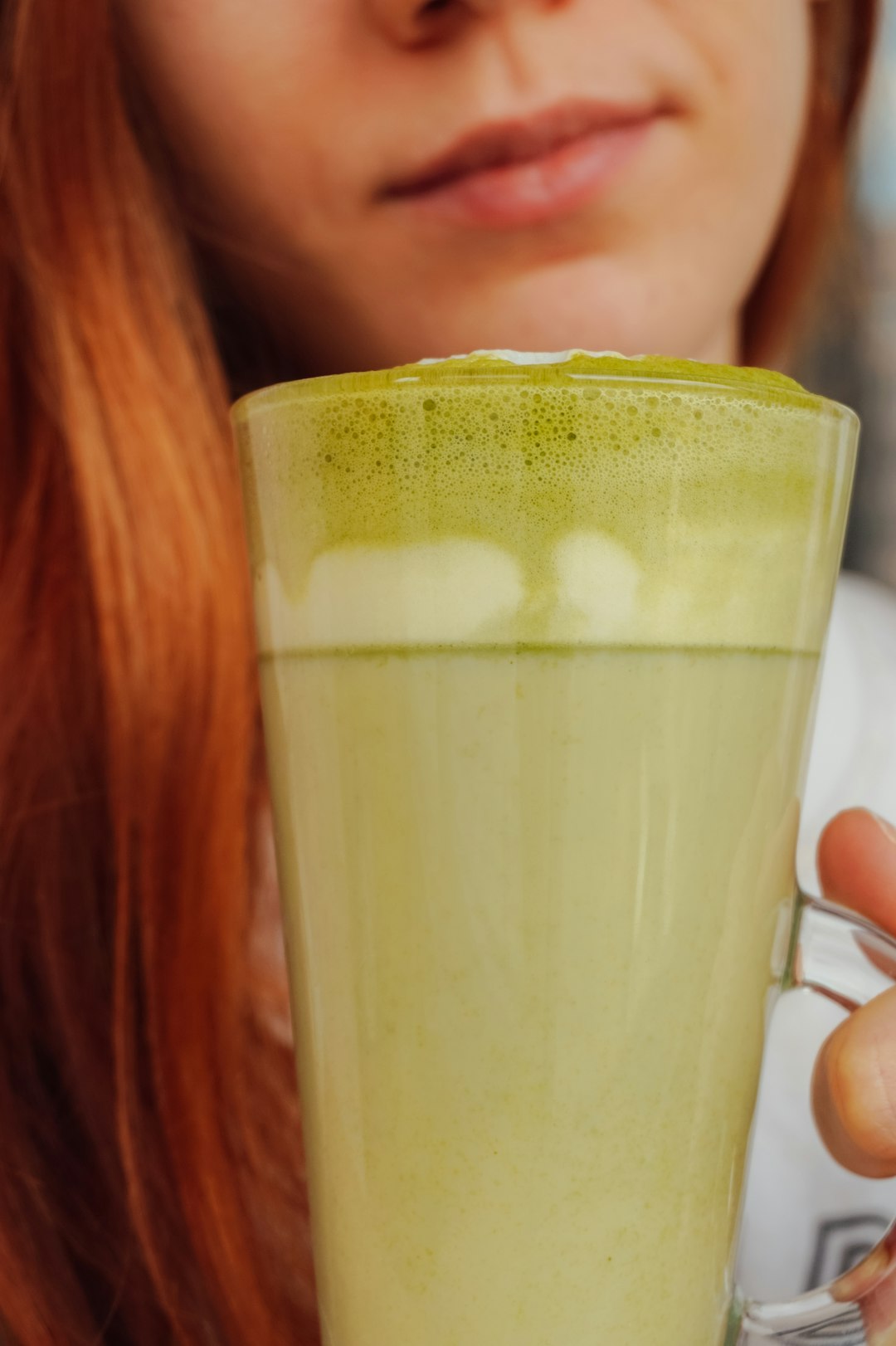 woman holding clear glass mug with white liquid