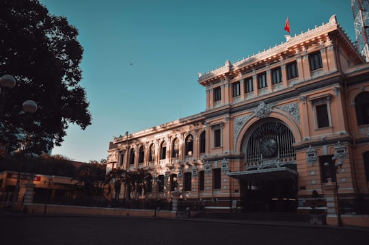 people walking near brown concrete building during daytime in Saigon Central Post Office Vietnam