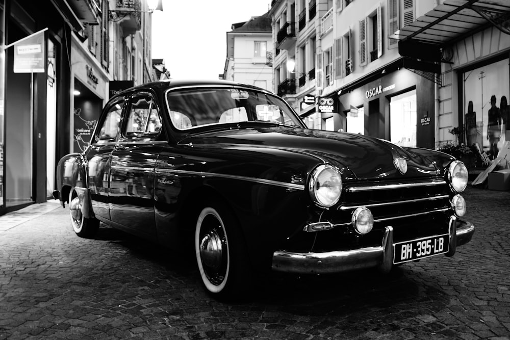grayscale photo of classic car parked on street