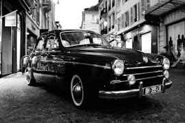 grayscale photo of classic car parked on street