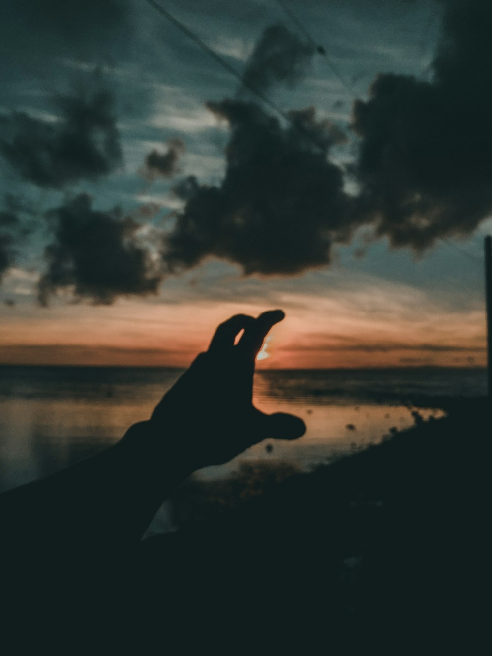 persons left hand near body of water during sunset