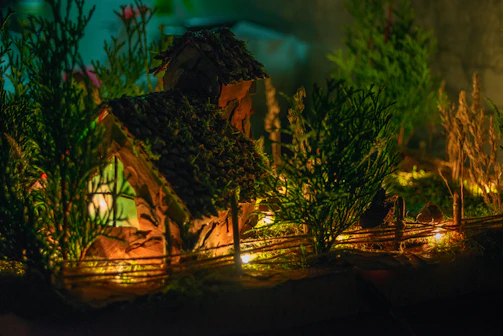 A charming DIY miniature house set on a soft, warm background with crafting tools nearby.
