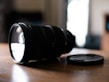 Close-up of a high-quality lens resting on a wooden table with soft natural light.