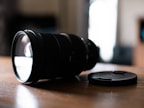 Close-up of a high-quality lens resting on a wooden table with soft natural light.