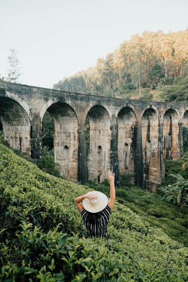 woman in black and white stripe long sleeve shirt standing on green grass field during daytime