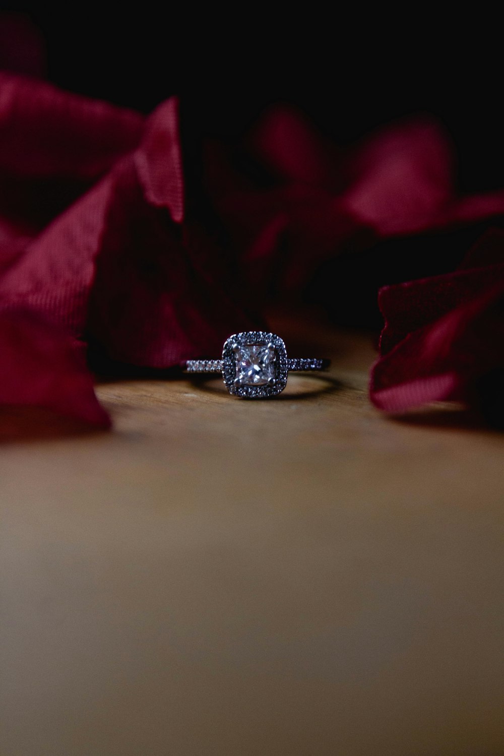 silver diamond ring on brown textile